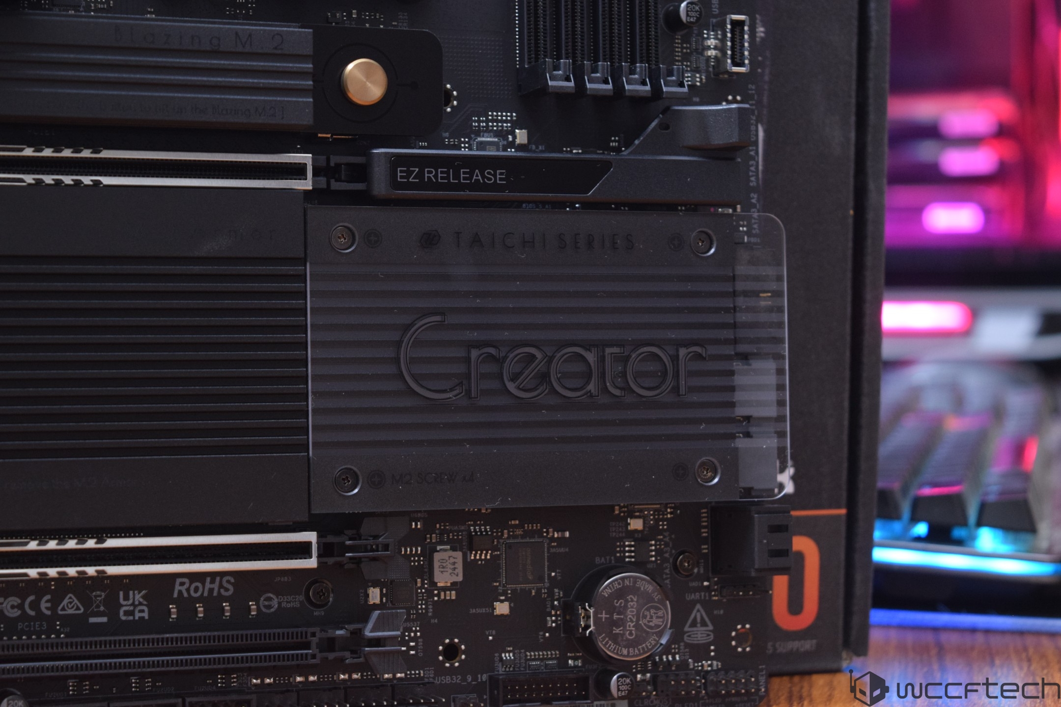 ASRock Taichi motherboard with Creator branding and EZ RELEASE text, on a computer assembly setup.