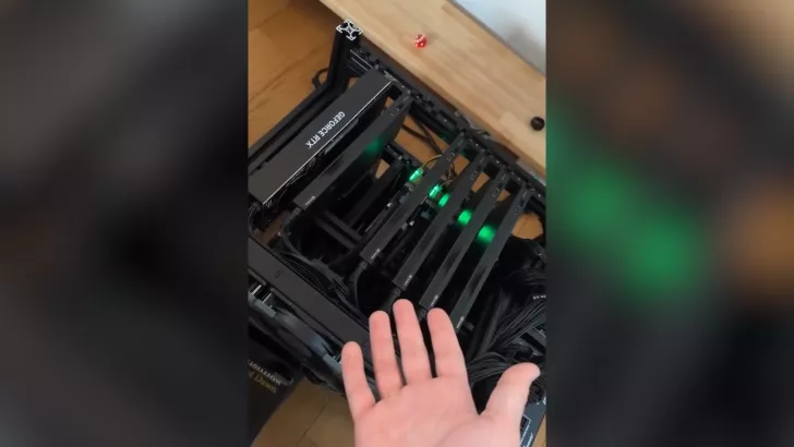 A hand gesturing towards multiple NVIDIA GeForce RTX graphics cards installed in a mining rig with green LED lights.