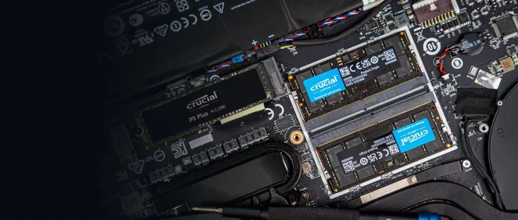 An open laptop reveals a Crucial P5 Plus M.2 2280 SSD and two Crucial DDR5 SODIMM memory modules installed on the motherboard.