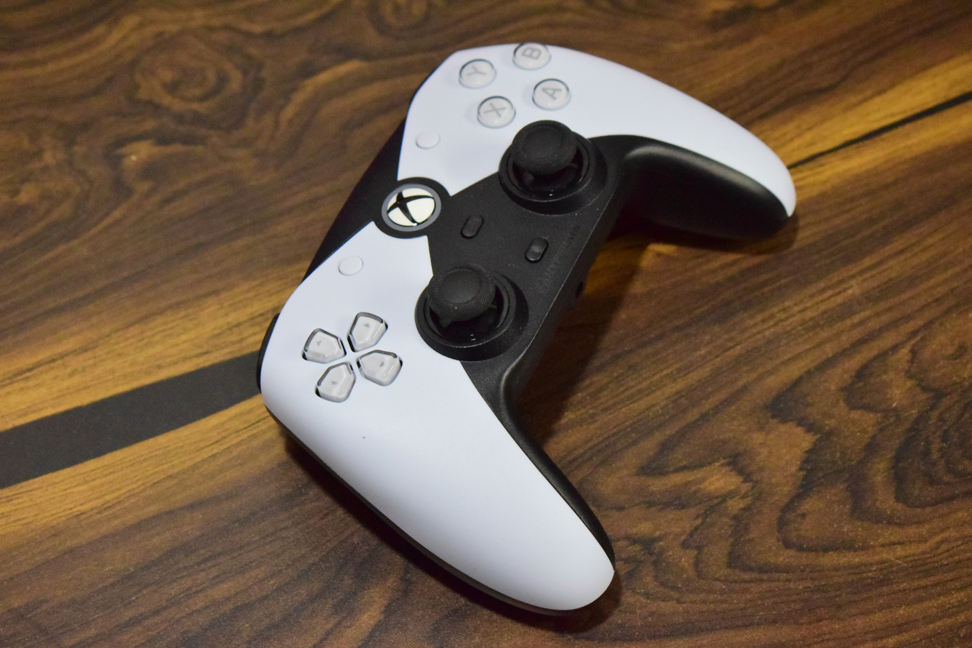 White Xbox controller resting on a wooden table.