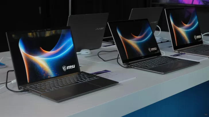 An array of MSI Prestige 16 laptops with vibrant display graphics are showcased on a white table.
