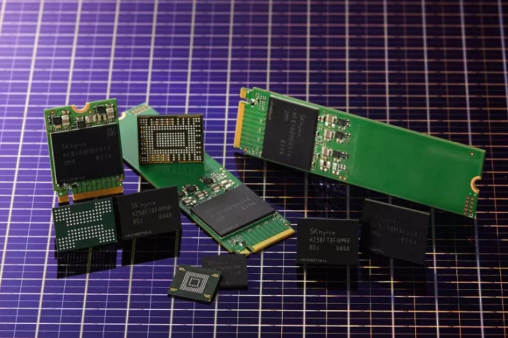 A collection of SK hynix memory chips and SSDs is displayed on a grid-patterned surface.