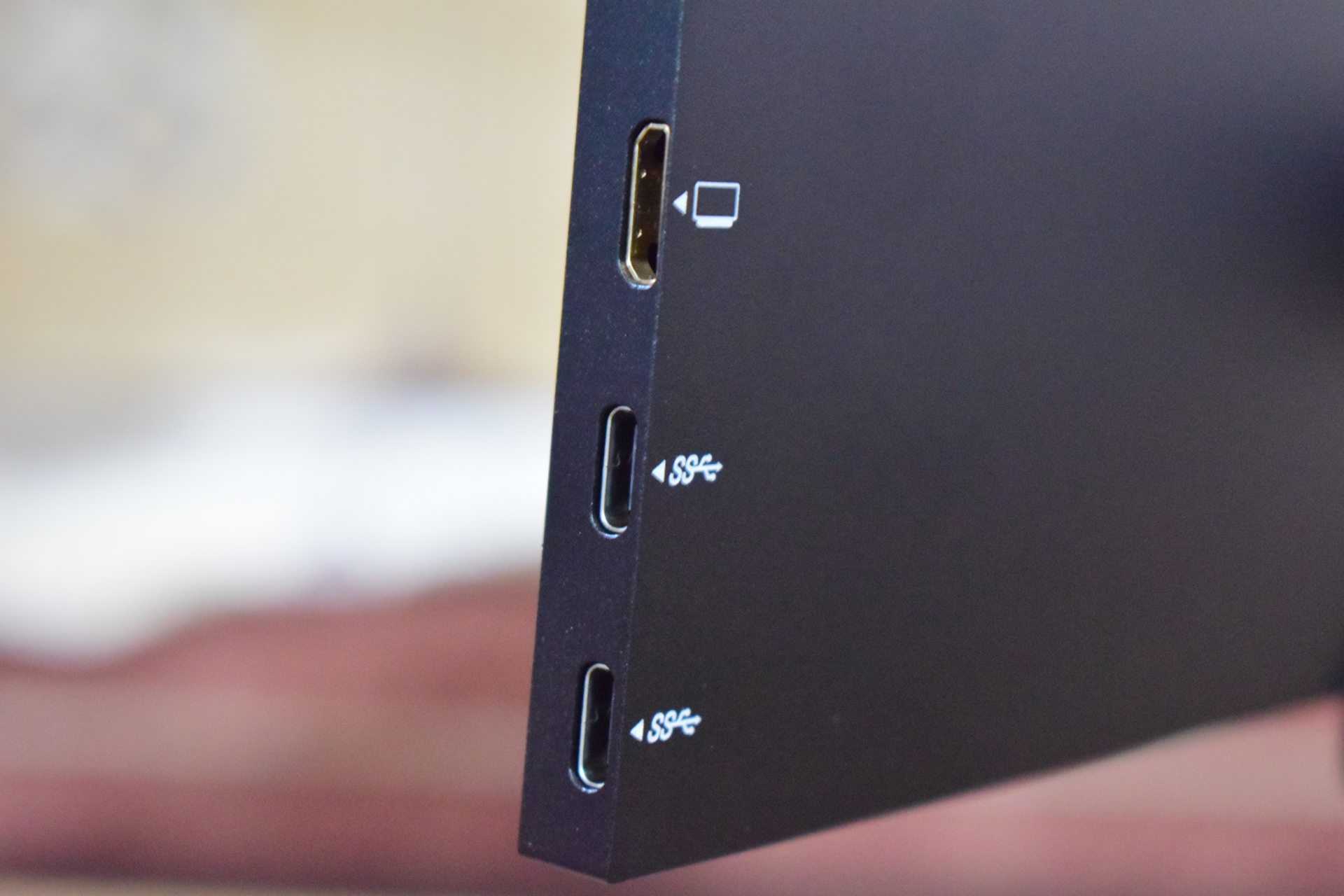 A close-up image shows a device edge with three ports: one HDMI, labeled with a monitor icon, and two USB-C ports each labeled with 'SS' and a USB icon.